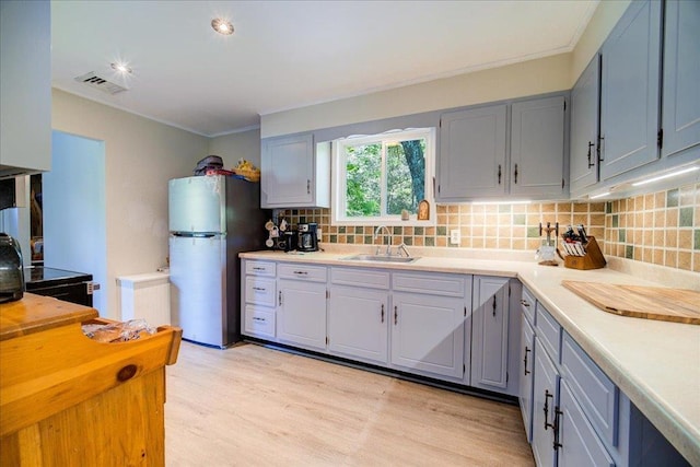 287 Norton Rd, Red Hook, NY 12571 - kitchen featuring freestanding refrigerator, a sink, tasteful backsplash, light wood-style flooring, and ornamental molding