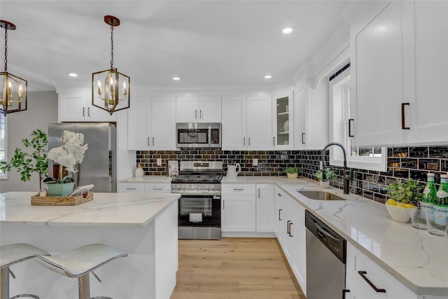 2614 Milburn Ave, Baldwin, NY 11510 - kitchen with appliances with stainless steel finishes, a chandelier, a sink, light wood finished floors, and pendant lighting
