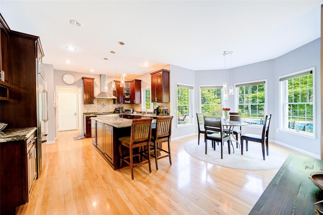 2 Marion Way, Lagrangeville, NY 12540 - kitchen with wall chimney exhaust hood, a kitchen island, light stone counters, plenty of natural light, and recessed lighting