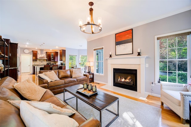 2 Marion Way, Lagrangeville, NY 12540 - living room featuring a chandelier, a glass covered fireplace, light wood-style flooring, crown molding, and recessed lighting