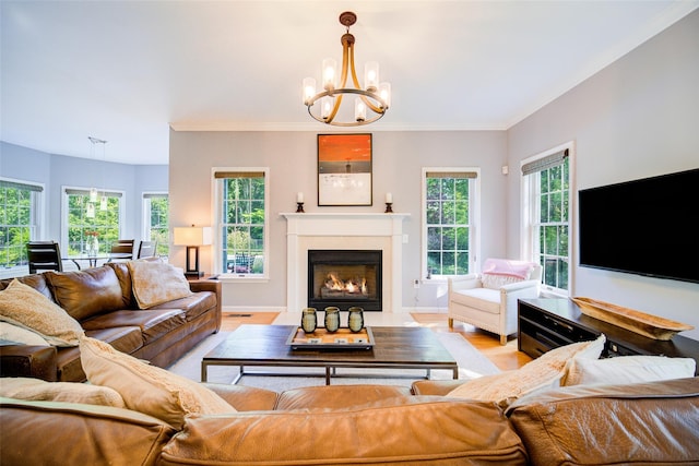2 Marion Way, Lagrangeville, NY 12540 - living room featuring a chandelier, light wood finished floors, a fireplace with flush hearth, and crown molding