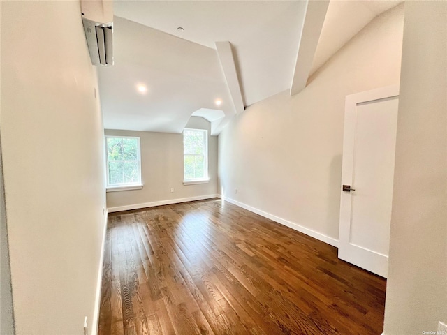56-75 136th St Unit 3B, Flushing, NY 11354 - spare room with wood finished floors, baseboards, and an AC wall unit