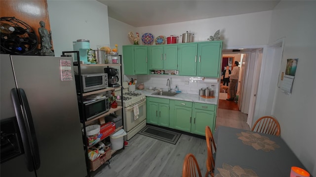 5214 92nd St, Elmhurst, NY 11373 - kitchen featuring appliances with stainless steel finishes, green cabinetry, a sink, light countertops, and light wood-style flooring