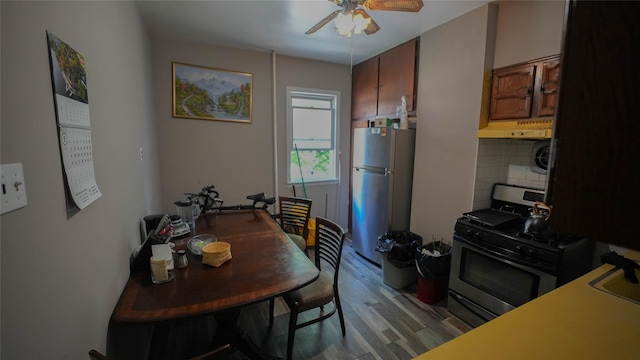 5214 92nd St, Elmhurst, NY 11373 - kitchen featuring freestanding refrigerator, under cabinet range hood, stainless steel gas stove, ceiling fan, and light wood-style flooring