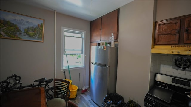 5214 92nd St, Elmhurst, NY 11373 - kitchen featuring freestanding refrigerator, stainless steel range oven, wood finished floors, backsplash, and exhaust hood