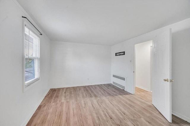 56 Mary St, Valley Stream, NY 11580 - empty room featuring radiator, light wood-style floors, and baseboards