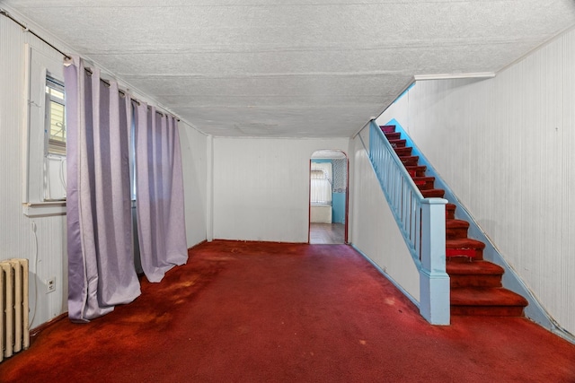 12104 Linden Blvd, South Ozone Park, NY 11420 - interior space featuring radiator heating unit, arched walkways, carpet floors, plenty of natural light, and a textured ceiling