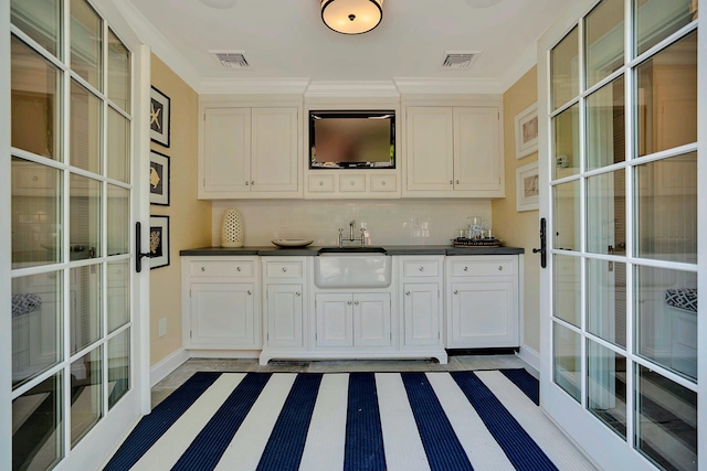 191 Elderfields Rd, Manhasset, NY 11030 - kitchen with a sink, dark countertops, baseboards, white cabinets, and ornamental molding