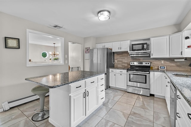 491 Toleman Rd, Rock Tavern, NY 12575 - kitchen with stainless steel appliances, decorative backsplash, a baseboard radiator, and white cabinets