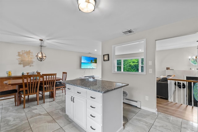 491 Toleman Rd, Rock Tavern, NY 12575 - kitchen with a baseboard heating unit, a chandelier, a center island, and dark stone countertops