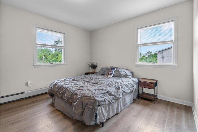 491 Toleman Rd, Rock Tavern, NY 12575 - bedroom with wood finished floors, baseboards, and a baseboard heating unit