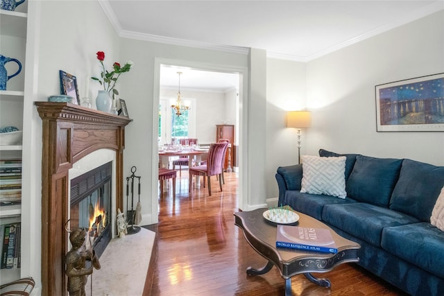 100 Castle Rd, Chappaqua, NY 10514 - living room with a lit fireplace, dark wood-type flooring, crown molding, a chandelier, and baseboards