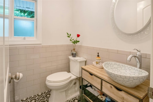 100 Castle Rd, Chappaqua, NY 10514 - bathroom featuring tile walls, a sink, toilet, and a wainscoted wall