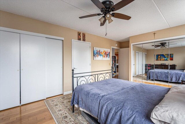 342 E 119th St Unit 6D, New York Manhattan, NY 10035 - bedroom featuring wood finished floors, multiple closets, a ceiling fan, and a textured ceiling
