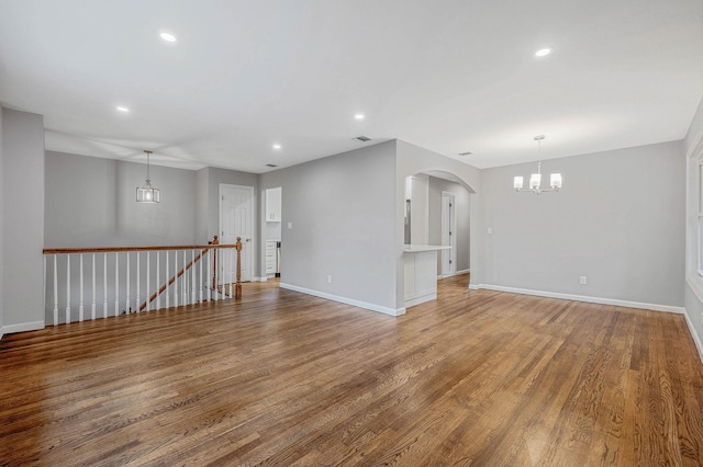 116 Amsterdam Ave, West Babylon, NY 11704 - empty room with a chandelier, recessed lighting, arched walkways, wood finished floors, and baseboards