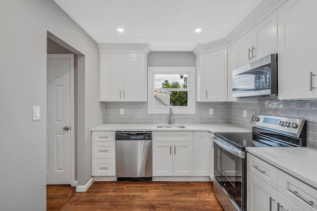 116 Amsterdam Ave, West Babylon, NY 11704 - kitchen with appliances with stainless steel finishes, a sink, dark wood-style flooring, tasteful backsplash, and white cabinetry