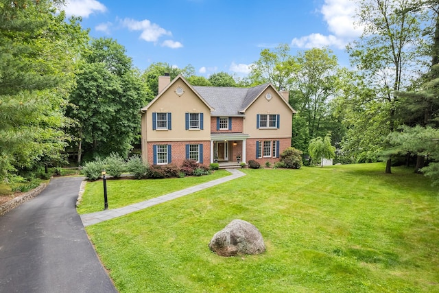 8 Upland Ct, South Salem, NY 10590 - traditional-style house with a chimney, brick siding, a front lawn, and stucco siding