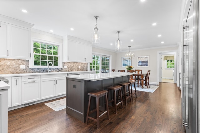 8 Upland Ct, South Salem, NY 10590 - kitchen featuring a kitchen island, decorative backsplash, white cabinetry, a kitchen bar, and light countertops