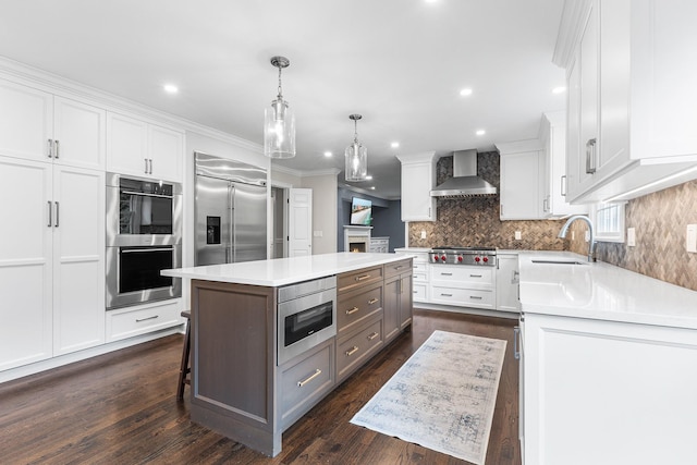 8 Upland Ct, South Salem, NY 10590 - kitchen with built in appliances, wall chimney exhaust hood, a sink, light countertops, and white cabinets