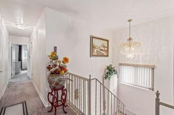 3226 165th St, Flushing, NY 11358 - hallway featuring a chandelier, an upstairs landing, carpet, and baseboards