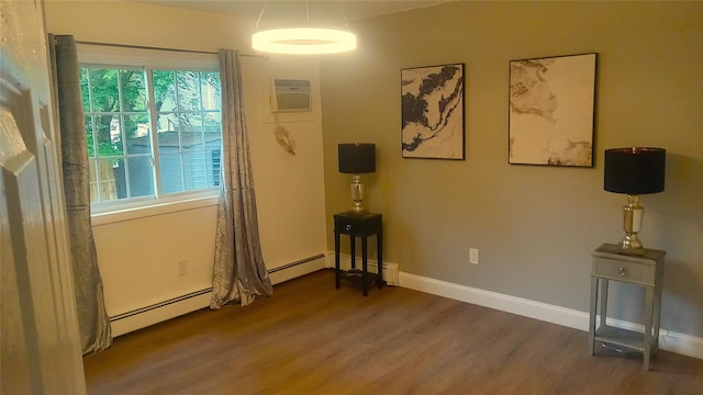 34 Park Ln, Medford, NY 11763 - unfurnished room with wood finished floors, a wall mounted air conditioner, a baseboard radiator, and baseboards