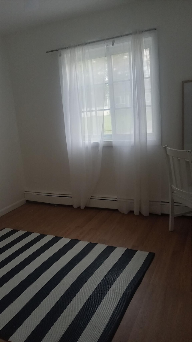 34 Park Ln, Medford, NY 11763 - unfurnished room featuring wood finished floors and a baseboard heating unit