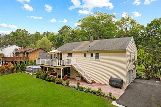 550 Saw Mill River Rd, Millwood, NY 10546 - back of property with oil tank, stairs, a deck, an attached garage, and a lawn