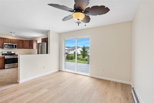 221 Tamerisk Ln, New Windsor, NY 12553 - kitchen featuring appliances with stainless steel finishes, a baseboard radiator, light wood finished floors, a ceiling fan, and baseboards