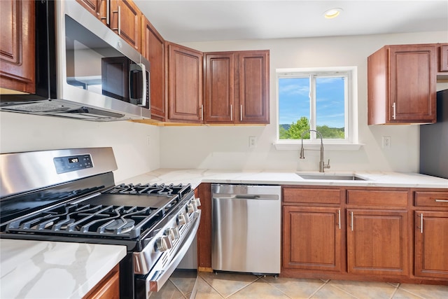 221 Tamerisk Ln, New Windsor, NY 12553 - kitchen with appliances with stainless steel finishes, a sink, brown cabinetry, light stone counters, and recessed lighting