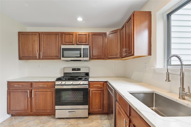 221 Tamerisk Ln, New Windsor, NY 12553 - kitchen with stainless steel appliances, a sink, brown cabinets, light tile patterned floors, and recessed lighting
