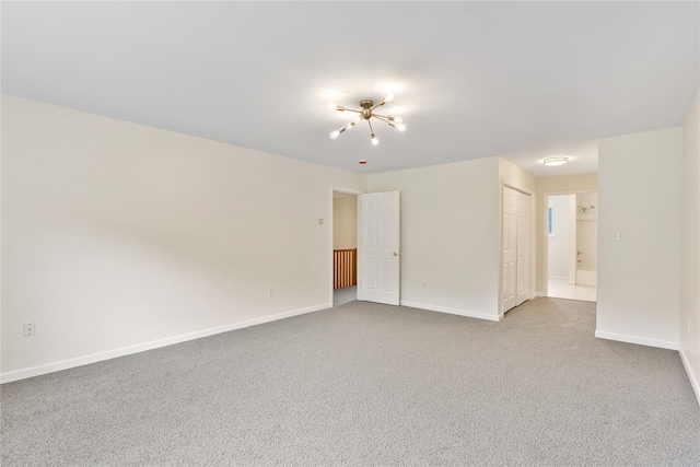 221 Tamerisk Ln, New Windsor, NY 12553 - carpeted empty room with baseboards and a chandelier