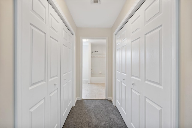 221 Tamerisk Ln, New Windsor, NY 12553 - corridor featuring dark colored carpet and baseboards