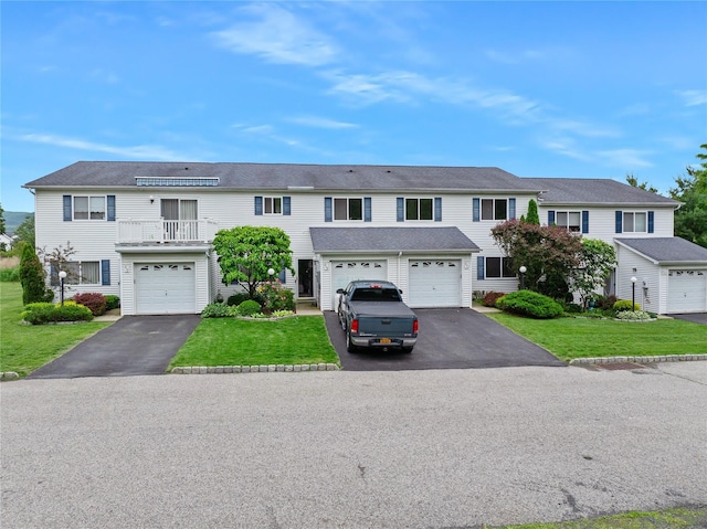 221 Tamerisk Ln, New Windsor, NY 12553 - townhome / multi-family property featuring asphalt driveway, a front lawn, an attached garage, and a balcony