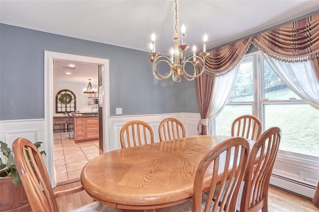 285 Willow Grove Rd, Stony Point, NY 10980 - dining room featuring a chandelier, a baseboard heating unit, a wainscoted wall, plenty of natural light, and a decorative wall