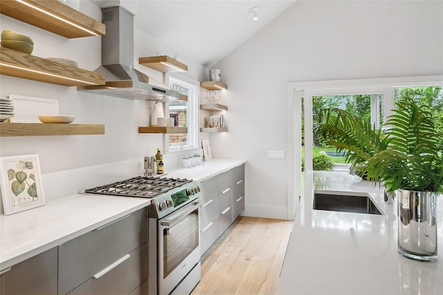 69 Bay View Dr W, Sag Harbor, NY 11963 - kitchen with open shelves, stainless steel range with gas stovetop, wall chimney exhaust hood, modern cabinets, and light wood-type flooring