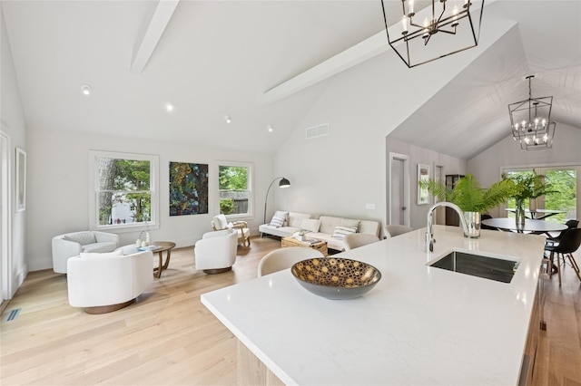 69 Bay View Dr W, Sag Harbor, NY 11963 - kitchen featuring a chandelier, a sink, open floor plan, high vaulted ceiling, and beamed ceiling
