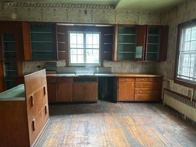 689 E 19th St, Brooklyn, NY 11230 - kitchen with open shelves, radiator heating unit, wallpapered walls, light wood finished floors, and brown cabinets
