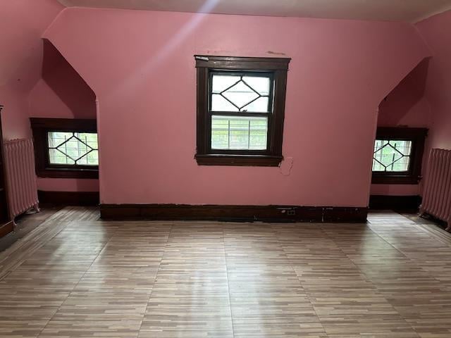 689 E 19th St, Brooklyn, NY 11230 - additional living space with vaulted ceiling, tile patterned floors, plenty of natural light, and radiator heating unit