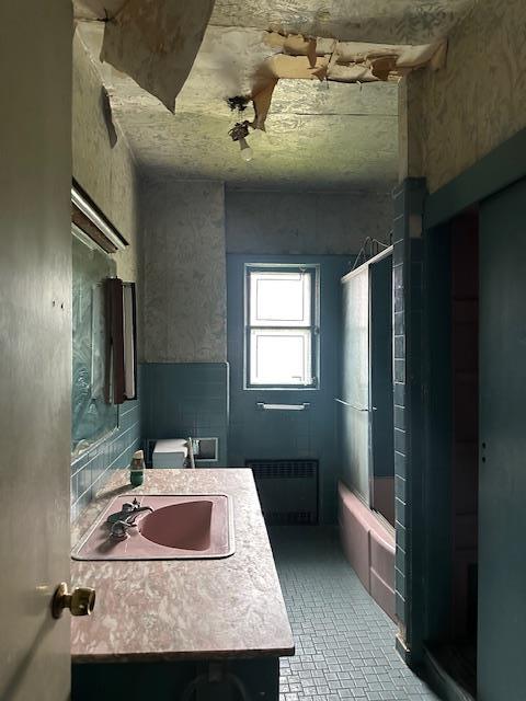 689 E 19th St, Brooklyn, NY 11230 - full bath with radiator heating unit, vanity, brick patterned floors, and bathing tub / shower combination