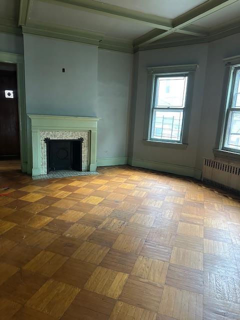 689 E 19th St, Brooklyn, NY 11230 - unfurnished living room with radiator, a fireplace with flush hearth, coffered ceiling, beamed ceiling, and baseboards