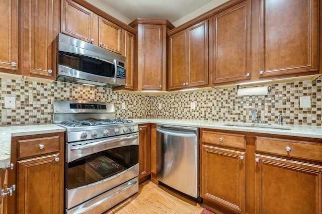 174 Spring Dr Unit 174, East Meadow, NY 11554 - kitchen featuring stainless steel appliances, a sink, brown cabinetry, and tasteful backsplash