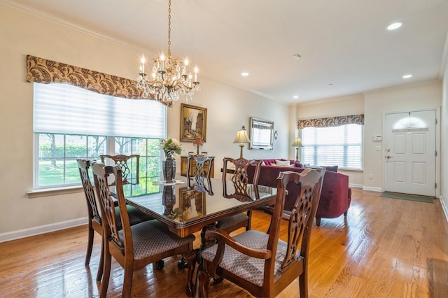 174 Spring Dr Unit 174, East Meadow, NY 11554 - dining area featuring healthy amount of natural light, a chandelier, baseboards, light wood finished floors, and crown molding