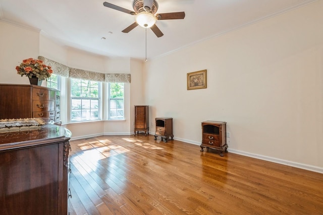 174 Spring Dr Unit 174, East Meadow, NY 11554 - living room with a wood stove, wood-type flooring, ornamental molding, ceiling fan, and baseboards
