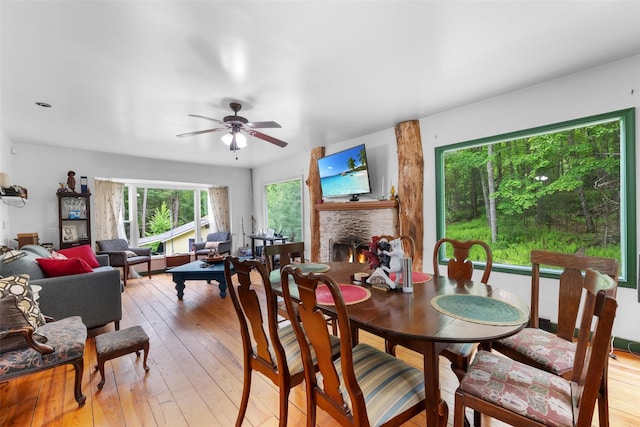 11 Waldweg Dr, Sparrowbush, NY 12780 - dining room with a lit fireplace, ceiling fan, and light wood-style flooring