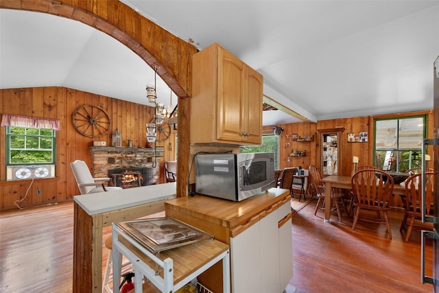 11 Waldweg Dr, Sparrowbush, NY 12780 - kitchen with lofted ceiling, wooden walls, light wood-type flooring, a fireplace, and arched walkways