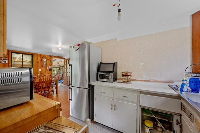 11 Waldweg Dr, Sparrowbush, NY 12780 - kitchen with freestanding refrigerator, light countertops, light wood-style flooring, and white cabinetry