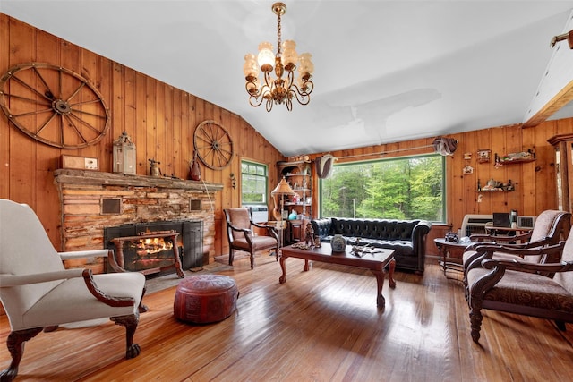 11 Waldweg Dr, Sparrowbush, NY 12780 - living room with wooden walls, plenty of natural light, lofted ceiling, wood finished floors, and a stone fireplace