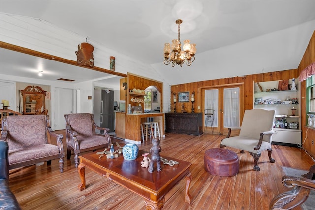 11 Waldweg Dr, Sparrowbush, NY 12780 - living room featuring lofted ceiling, wood walls, a chandelier, wood finished floors, and french doors