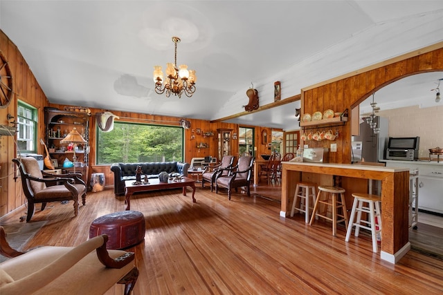 11 Waldweg Dr, Sparrowbush, NY 12780 - living area featuring wood walls, a chandelier, hardwood / wood-style flooring, and vaulted ceiling