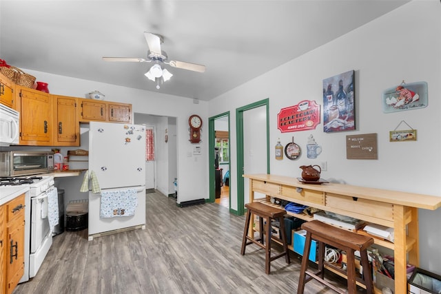 11 Waldweg Dr, Sparrowbush, NY 12780 - kitchen featuring white appliances, light countertops, light wood-type flooring, a ceiling fan, and baseboards